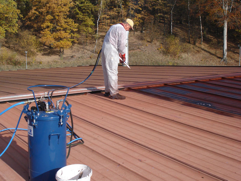 sagu® coating Bauwerksabdichtung Aufbringung Flachdach, auf welches mittels eines Spritzverfahrens dunkle Bauwerksabdichtung aufhetragen wird
