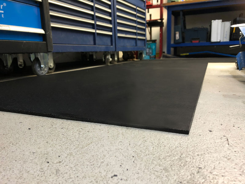 sagu® matting Arbeitsplatzmatten schwarze Gummimatte auf dem Boden vor einer Werkbank in einer Werkstatt