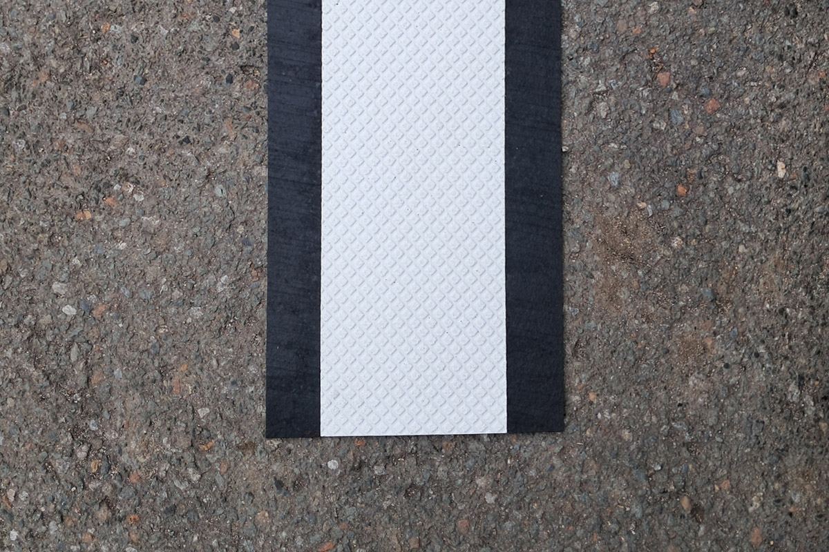 sagu®matting Fahrbahnmarkierungen (mobil) schwarzer Antirutschstreifen, darauf geklebt weißes Fahrbahnmarkierungsband